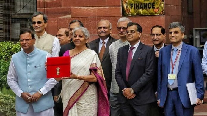 மத்திய நிதியமைச்சர் நிர்மலா சீதாராமன் நாடாளுமன்றத்தில் மத்திய பட்ஜெட்டை தாக்கல் செய்ய தனது அலுவலகத்தை விட்டு வெளியேறும்போது இந்திய அரசின் சின்னத்துடன் ஒரு கோப்புறையை வைத்திருக்கிறார். படம்: பிரவீன் ஜெயின்/திபிரிண்ட்