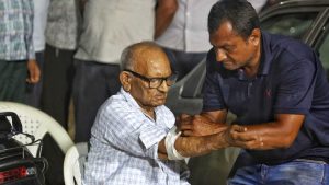ரத்த மாதிரி எடுக்கப்படும்போது ராமன்பாய் படேல் கையை நீட்டி அமர்ந்திருக்கிறார். அவர் தனது பேத்தி நிராலியைத் தேடி வந்துள்ளார் | பிரவீன் ஜெயின் | திபிரிண்ட்
