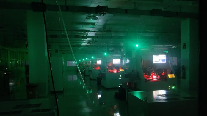 தமிழ்நாட்டின் காஞ்சிபுரத்தில் உள்ள பாலிமேடெக்கின் இருண்ட தொழிற்சாலையில் ரோபோக்கள் குறைக்கடத்தி சில்லுகளை இணைக்கின்றன | புகைப்படம்: அம்ர்தன்ஷ் அரோரா | திபிரிண்ட்