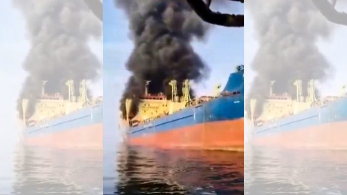 ஓமானின் முசந்தம் தீபகற்பத்தில் ஈரானிய இராணுவத்தின் தாக்குதலுக்கு உள்ளான பிறகு, 15 இந்திய பணியாளர்களுடன் பலாவ் கொடியுடன் கூடிய எண்ணெய் டேங்கரில் இருந்து புகை கிளம்புகிறது. | PTI