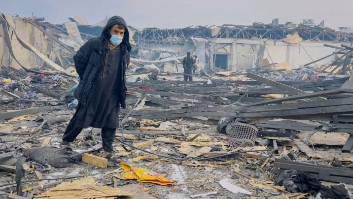 ஆப்கானிஸ்தானின் காபூலில், பாகிஸ்தானின் வான்வழித் தாக்குதலில் அழிக்கப்பட்ட மறுவாழ்வு மருத்துவமனை அமைந்த இடத்தில், ஒருவர் நடந்து செல்கிறார் — 17 மார்ச் 2026 | REUTERS/Sayed Hassib