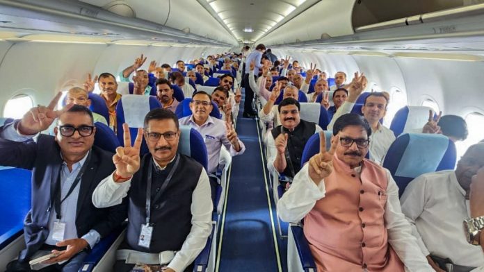 நொய்டா சர்வதேச விமான நிலையத்தின் முதல் விமானம் புறப்படும்போது, ​​பயணிகள் வெற்றிச் சின்னத்தைக் காட்டுகின்றனர் | ANI